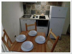 cocina pequeña con mesa de madera y nevera blanca en Dimora Polimnia, en Polignano a Mare