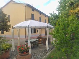 patio con ombrellone bianco di fronte a una casa di Appartamento Grey ad Arezzo