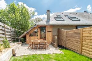 a backyard with a table and chairs and a fence at Gite dans corps de ferme in Groisy