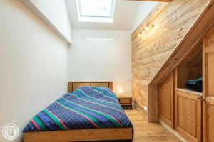 a bedroom with a bed and a wooden wall at Gite dans corps de ferme in Groisy +1 photo