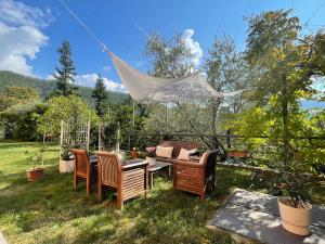 a group of chairs and a table in a yard at La Casa nel Bosco - In collina a 10 minuti dal mare in Casarza Ligure