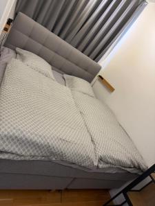 a bed with a gray bed frame and a window at Bright and inviting apartment in Frederiksberg in Copenhagen