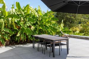 Una mesa y sillas con una sombrilla frente a las plantas. en Demerzicht, en Aarschot