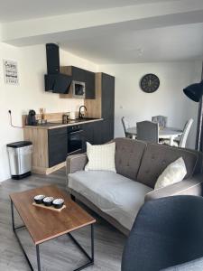 un soggiorno con un divano e un tavolo di le relais des étangs a Mareuil-Caubert Altre 9 foto