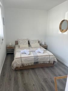 una camera da letto con un letto grande con pavimenti in legno di le relais des étangs a Mareuil-Caubert
