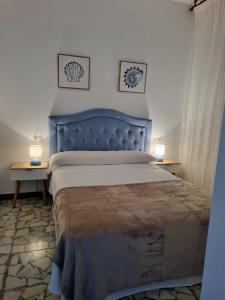 1 cama con cabecero azul en un dormitorio en O Curro de Arou, en Arou