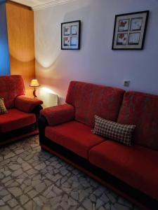 sala de estar con sofá rojo y lámpara en O Curro de Arou, en Arou