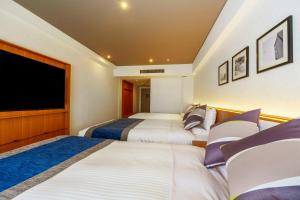 a hotel room with two beds and a flat screen tv at Hotel Mystays Premier Hamamatsucho in Tokyo