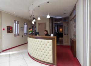a woman sitting at a bar in a hotel lobby at Hotel von Euch in Meppen