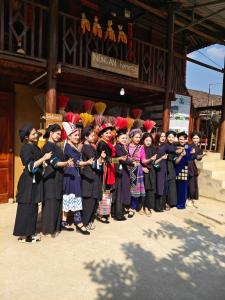 a group of people standing in front of a building at Nùng An homestay in Quảng Uyên