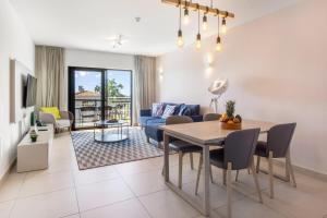 a living room with a table and a couch at Quinta do Algarvio Village in Carvoeiro +19 photos