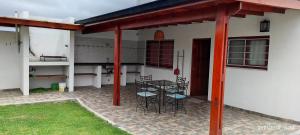 a patio with a table and chairs in a house at Casa temporada 2026 in Miramar