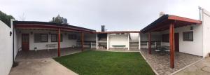 a house with a courtyard with a grass yard at Casa temporada 2026 in Miramar