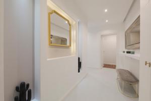 pasillo con puerta con espejo y silla en Milan Royal Suites - Centro Brera, en Milán 271 fotos más