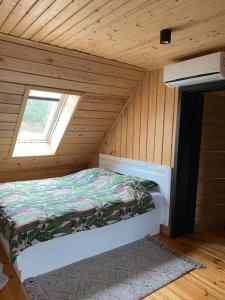 a bed in a small room with a window at Agroturystyka Podlasie dom nad stawem in Dobrzyniewo Duże