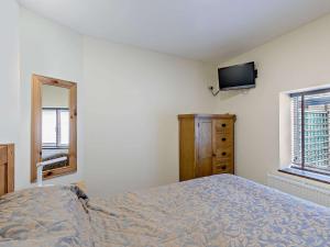 a bedroom with a bed and a tv on the wall at 1 Bed in Ross-on-Wye 49910 in Walford