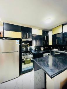 a kitchen with black and white cabinets and a refrigerator at بورتو سعيد شاليهات لإيجار من المالك in Port Said +42 photos