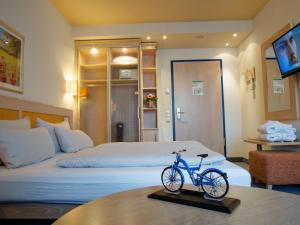 a room with a bed with a bike on a table at Hotel von Euch in Meppen