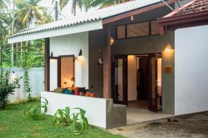 a villa with a view of the front of the house at Turtle Bay Cottage in Kosgoda