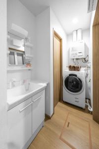 a kitchen with a washing machine and a sink at Charmant in Minamifurano