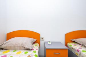 two beds with orange headboards in a room at Lifto Hostel in Voyvodinovo