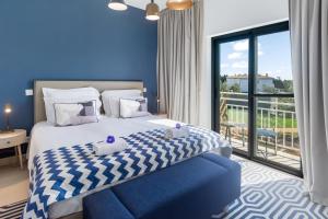 a bedroom with a bed and a large window at Quinta do Algarvio Village in Carvoeiro