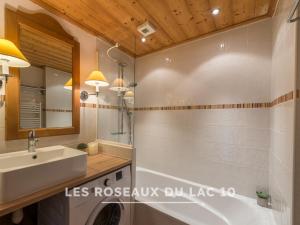 a bathroom with a sink and a tub and a mirror at Les Roseaux du Lac - 7 appartements situés dans une résidence posée au bord du lac d'Annecy in Duingt +83 photos