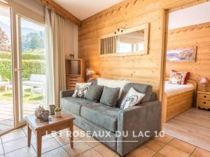 a living room with a couch and a bed at Les Roseaux du Lac - 7 appartements situés dans une résidence posée au bord du lac d'Annecy in Duingt