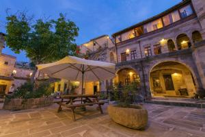 a table and an umbrella in front of a building at Century Cave Hotel in Goreme