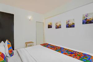a white room with a bed and some paintings on the wall at Via PRG Park in Benaulim