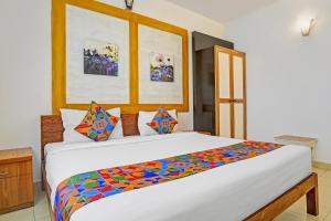 a bedroom with a large bed with a colorful comforter at Via PRG Park in Benaulim