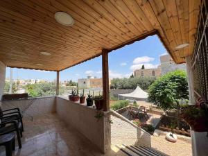 a patio with a wooden roof with potted plants at Spacious Villa near Ma'in Hot Springs & Mount Nebo in Umm Juraysāt