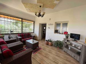 a living room with a couch and a tv at Spacious Villa near Ma'in Hot Springs & Mount Nebo in Umm Juraysāt