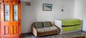 a room with a bed and a chair next to a door at Casa temporada 2026 in Miramar