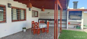 a patio with a table and chairs in a house at Casa temporada 2026 in Miramar