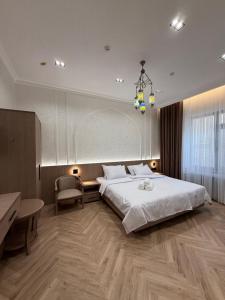 a bedroom with a large white bed and a desk at Old Town Hotel in Samarkand