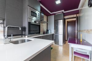 una cocina con fregadero y estufa horno superior en Apartamento Brétema, en Altamira
