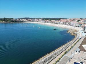 Una vista de una playa con barcos en el agua. en Apartamento Brétema, en Altamira