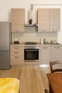 a kitchen with stainless steel appliances and wooden cabinets at Borgo nel Vigneto in Erbusco