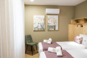 a bedroom with two beds and a chair at versão b in Ansião