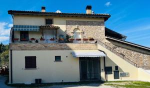 a building with a balcony with chairs on it at Aria di Fiume in Ascoli Piceno