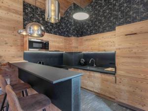 eine Küche mit Theke und Spüle und Holzwänden in der Unterkunft Bel appartement moderne, proche des pistes, à Méribel - FR-1-565-98 in Les Allues + 9 Fotos