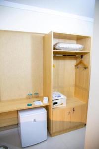 阿纳波利斯House Inn Hotel - Anashopping的一个小房间，里面有一台白色冰箱和一个架子
