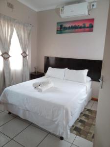 a bedroom with a white bed and a window at Vuya Nathi Bed and Breakfast in Manzini +51 photos