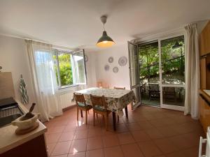a kitchen with a table and chairs in a room at La Casa nel Bosco - In collina a 10 minuti dal mare in Casarza Ligure