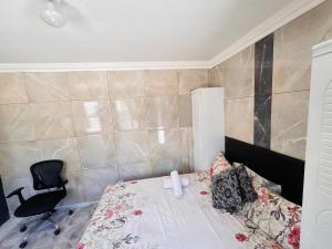 Un pequeño dormitorio con una cama y una silla. en Brown Accomodation, en Cape Town