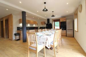 a dining room with a table with chairs and a kitchen at La Clé des Champs à Bussang - Gîte tout confort dans les Hautes Vosges in Bussang