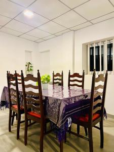 a dining room table with a purple table cloth on it at Villa Eco Stay in Tangalle