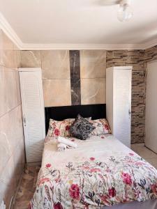 Un dormitorio con una cama grande con flores. en Brown Accomodation, en Cape Town