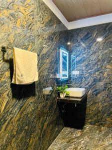 a bathroom with a stone wall with a sink and a mirror at Villa Eco Stay in Tangalle